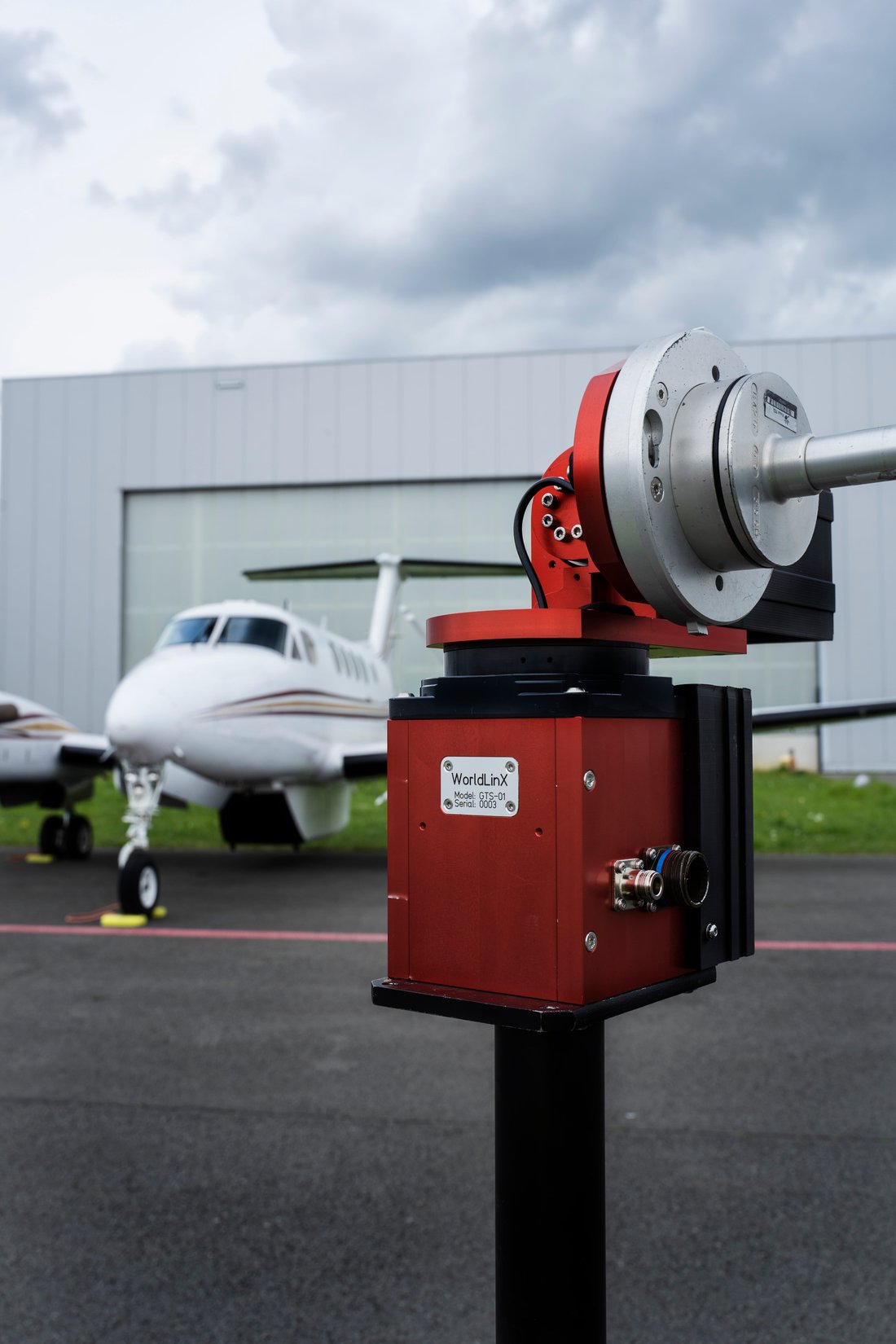 WorldLinX GTS-01 auto-tracking antenna pedestal on the ramp, with a King Air in the background